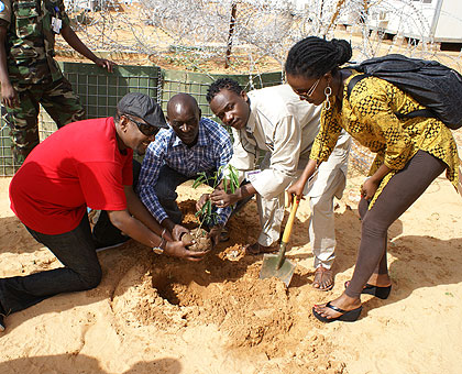 TAKING MUSIC TO DARFUR: Rwandan artistes Intore Massamba (L), Mani Martin (2nd right) and Shanel (R) plant a tree in Darfur. The three were part of a group of Rwandan artistes who performed to an audience of UNAMID peacekeepers and officials in western Su