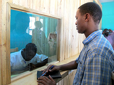 A clerk serves a member at one of the Umurenge Saccos. The New Times / File.