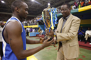Sports Minister Protais Mitali hands over the trophy to Junior Hoops Captain Pascal Karekezi yesterday.(Photo R.Spector)