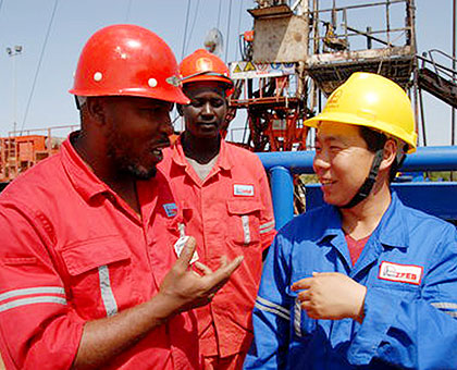 A Chinese engineer talks with two African colleagues on a project in Africa. Net photo.