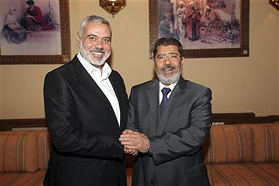 Egypts president Mohamed Mursi (R) shakes hands with Senior Hamas leader Ismail Haniyeh.  Net photo.