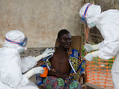 Health officials examine Ebola patient.