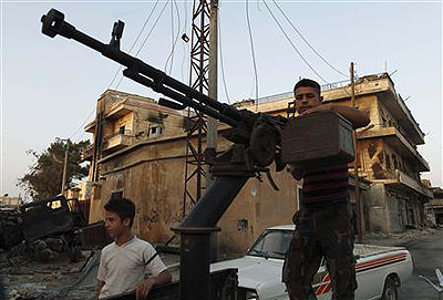 A Free Syrian Army member stands by his anti-aircraft machine gun during their patrol in Attarib, on the outskirts of Aleppo province July 30. Net photo.