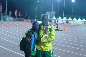 Robert Kajuga and his coach Innocent Rwabuhihi enjoy the moment after competing in the 10,000m men's final on Saturday night. Net photo.