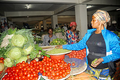 A woman sells vegetables at the City Market. The New Times / John Mbanda.