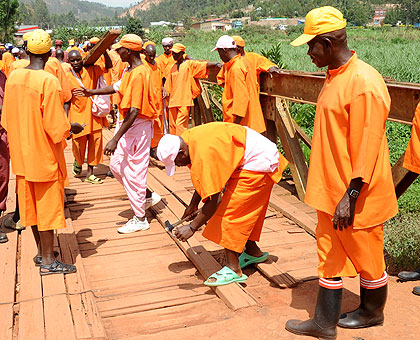 Prisoners repair a bridge. Some will receive free eye treatment. The New Times / File.