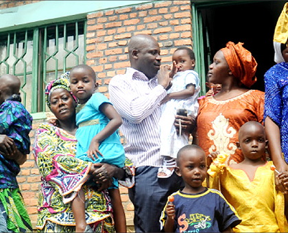 Parents with adopted children at the closing of one of the orphanage centres in Kigali early this year. The New Times / File.