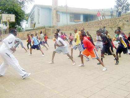 Former national basketball team Point Guard Karim Nkusi (L) teaching the young kids the Jab step. Courtesy photo.