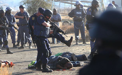 Police surround the bodies of striking miners after opening fire on a crowd at the Lonmin Platinum Mine near Rustenburg, South Africa, Thursday, Aug. 16, 2012. An unknown number of people have been killed and injured. Net photo.