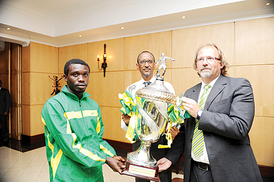 Yanga FC Captain Nadir Haroub Cannavaro and Head coach Tom Saintfiet present the 2012 Cecafa-Kagame Cup title to President Kagame yesterday. Photos/Village Urugwiro.