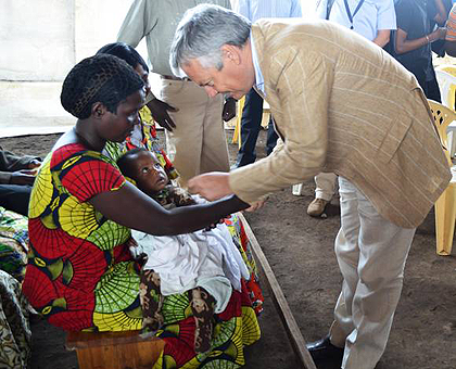 Belgian Deputy Prime Minister Didier Reynders talks to a woman in a refugee camp in Rubavu. The New Times, Sam Nkurunziza