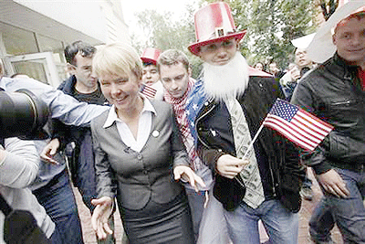 Opposition activist Yevgeniya Chirikova (L, front) walks beside an activist (2nd R, front) from a pro-Kremlin civil organisation, after visiting an election commission office. Net photo