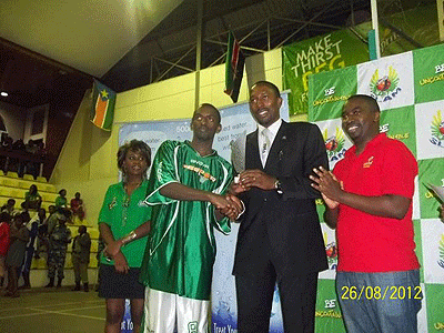 Espoir's Aristide Mugabe  receives his MVP Award from FUBA president Ambrose Tashobya.  The New Times / Courtsey.