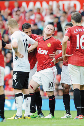 Wayne Rooney (C) winces after a gash to his leg. Net photo.