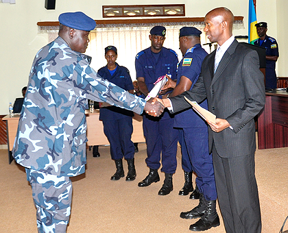 The Minister of Internal Security, Sheikh Musa Fazil Harelimana, giving a certificate to a participant from South Sudan. The New Times / Courtesy.