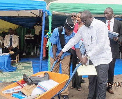 Prime Minister,  Dr Pierre Damien Habumuremyi giving work equipments to one of the graduating students. The Sunday Times / Sam Nkurunziza.