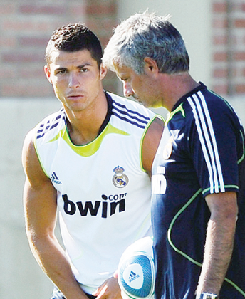 Real Madrid forward Cristiano Ronaldo (L)  looks at coach Jose Mourinho during a training session. Net photo.