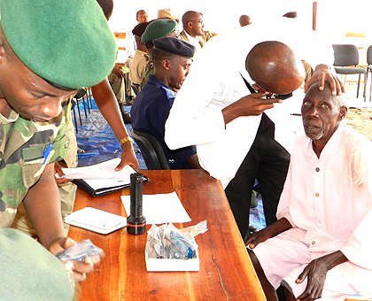 Rwanda Military Hospital ophtamolohists attend to an inmate at Nsinda prison yesterday.  The New Times / S. Rwembeho.