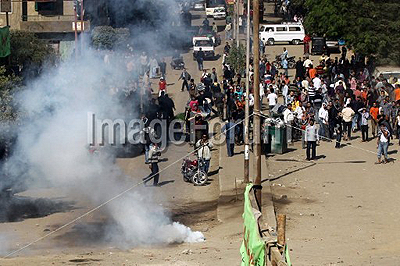 Egyptian Christians flee after riot police fire tear gas on demonstrators during deadly clashes over the refusal of permission for a new Coptic church, in Cairo on November 24, 2010. AFP Photo.