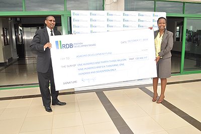 The Minister of Finance John Rwangombwa receives a dummy cheque from RDB acting CEO Clare Akamanzi yesterday. The New Times / Courtesy.