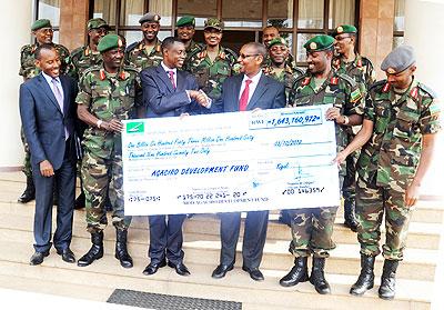 Defence Minister Gen. James Kabarebe (3rd left) flanked by RDF senior officers hands a cheque  meant for Agaciro Development Fund to Finance Minister John Rwangombwa on Wednesday.  The Sunday Times / John Mbanda.