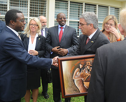 Education Minister Vincent Biruta (L) shakes hands with head of Rhineland-Palatinate delegation Roger Lewentz as Local Government Minister James Musoni (2nd right) looks on yesterday.  The New Times/ John Mbanda. 