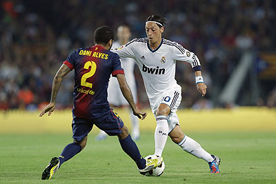 Barcelonau2019s Daniel Alves (L) duels for the ball with Real Madridu2019s Mesut Ozil during the La Liga match at the Camp Nou Stadium. Net photo.