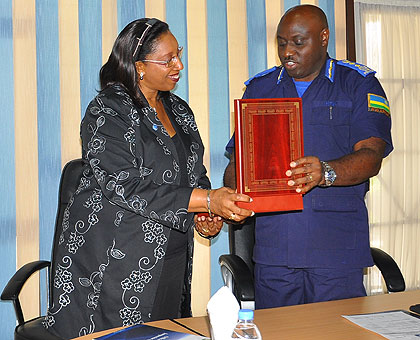 Inspector General of Police, Emmanuel K. Gasana hands a gift to UN Assistant Secretary General Mbaraga Gasarabwe Clotilde. The New Times / Courtesy.