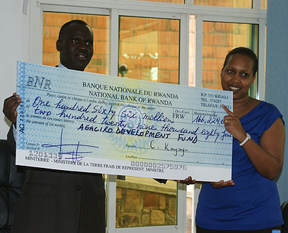  Minister Stanislas Kamanzi (L) hands a dummy checque to Finance Ministry PS Kampeta Sayinzoga. Agaciro fund has since accumulated to Rwf22 billion.