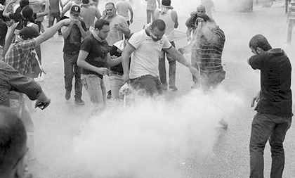 Lebanese policemen fire tear gas during clashes with angry protesters who attempted to storm Lebanese government offices on Sunday after the funeral of slain intelligence officer. Net photo.