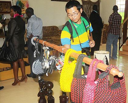 A customer looks at Rwandan art crafts. The Sunday Times / John Mbanda.