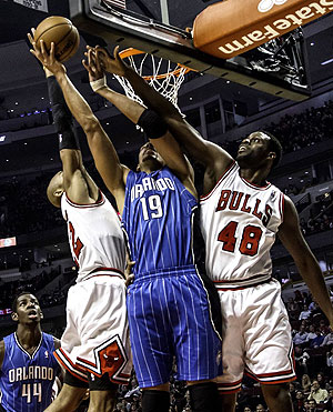 Bulls' Taj Gibson (22) and Nazr Mohammed (48) put defensive pressure on Orlando Magic's Gustavo Avon. Net photo.