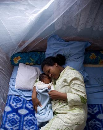 A mother sleeping under  a mosquito net with her child. The New Times / File.