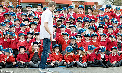Gerrard poses  with children from his former school on the eve of his 100th England cap. Net photo.