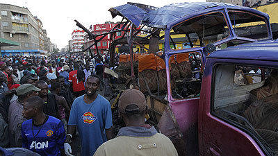 People look at the wreckage of the bus ripped by the grenade attack. Net photo.