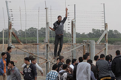 Palestinian youths gathered at the border fence after the shooting. Net photo