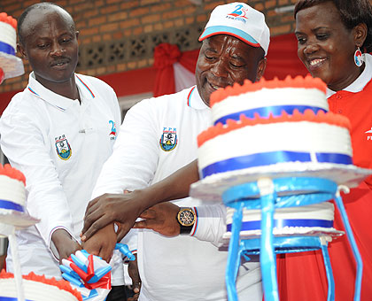 Governor Bosenibamwe (C), Mayor Kangwagye cut a cake during the celebrations. The New Times / Courtesy.