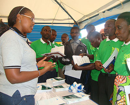 A BDF employee talks to farmers at the fiunance fair which concluded on Wednesday. The New Times / Courtesy.