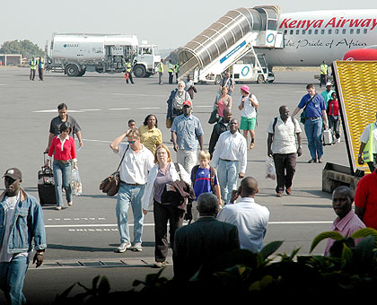 A cross section of passengers alight from a plane at Kigali International Airport. African travellers to Rwanda will get visas upon arrival. The New Times / File.