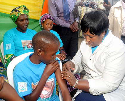 Health minister Dr Agnes Binagwaho immunises a girl against cervical cancer in Karongi District recently. The New Times / John Mbanda.
