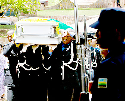 Police officers carry the late Aloisea Inyumba to her final resting place on Monday. The New Times / File.