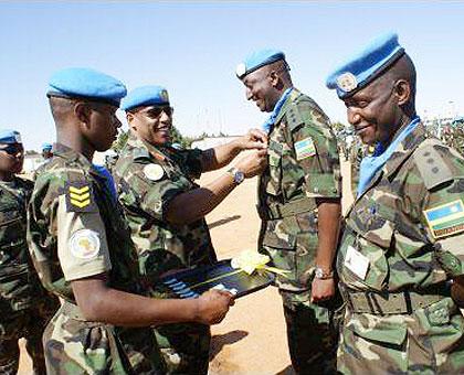 UNAMID Force Commander, Lt Gen Patrick Nyamvumba decorating a RDF officer serving in Darfur. Sunday Times/Courtesy.