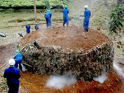The pile of wooden logs, which is essentially placed in a circle, leans against a chimney to control gas emission. The New Times / File.