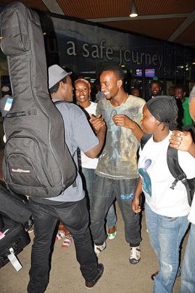 Alpha (with guitar) is mobbed by family and fans on arrival.