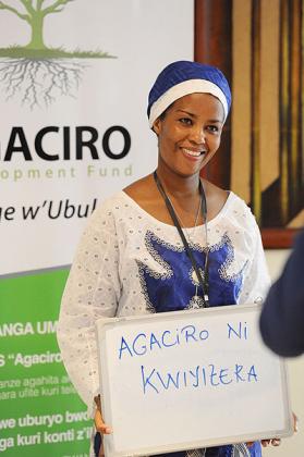 A woman displays a play card for Agaciro Development Fund during the fundu2019s launch in Kigali in August. The New Times/File.