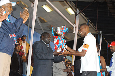 RPF Vice Chairman, Christophe Bazivamo hands over the Silver Jubilee trophy to APR captain Jean Baptista Mugiraneza at Amahoro national Stadium last night.  The New Times / Courtesy.