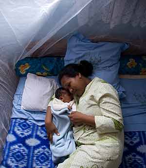 A mother and her baby under a mosquito net. The New Times / File.