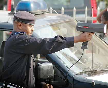 A Police officer checks traffic speed on a highway.  The New Times/File.