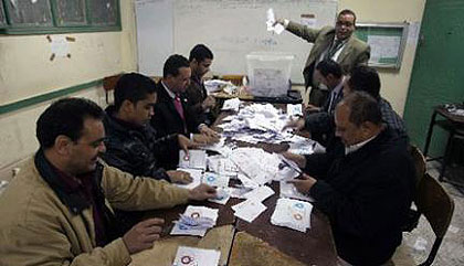 Polling station officials deposit ballots during the second round of a referendum on a new draft constitution in Giza, south of Cairo, on December 22. Net photo.