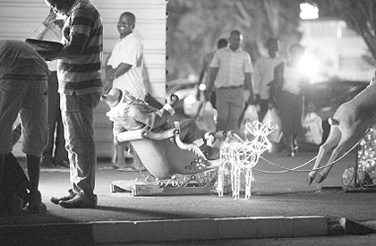 In this photo taken late Thursday Dec. 20, 2012, people walk past Christmas decorations at a shopping mall in Harare, Zimbabwe. Zimbabwe will join the rest of the world in celebrating the Christmas season in a manner that reflects its tradition and culture. Thousands of people are set to travel across the country to be with their families in rural areas. 
